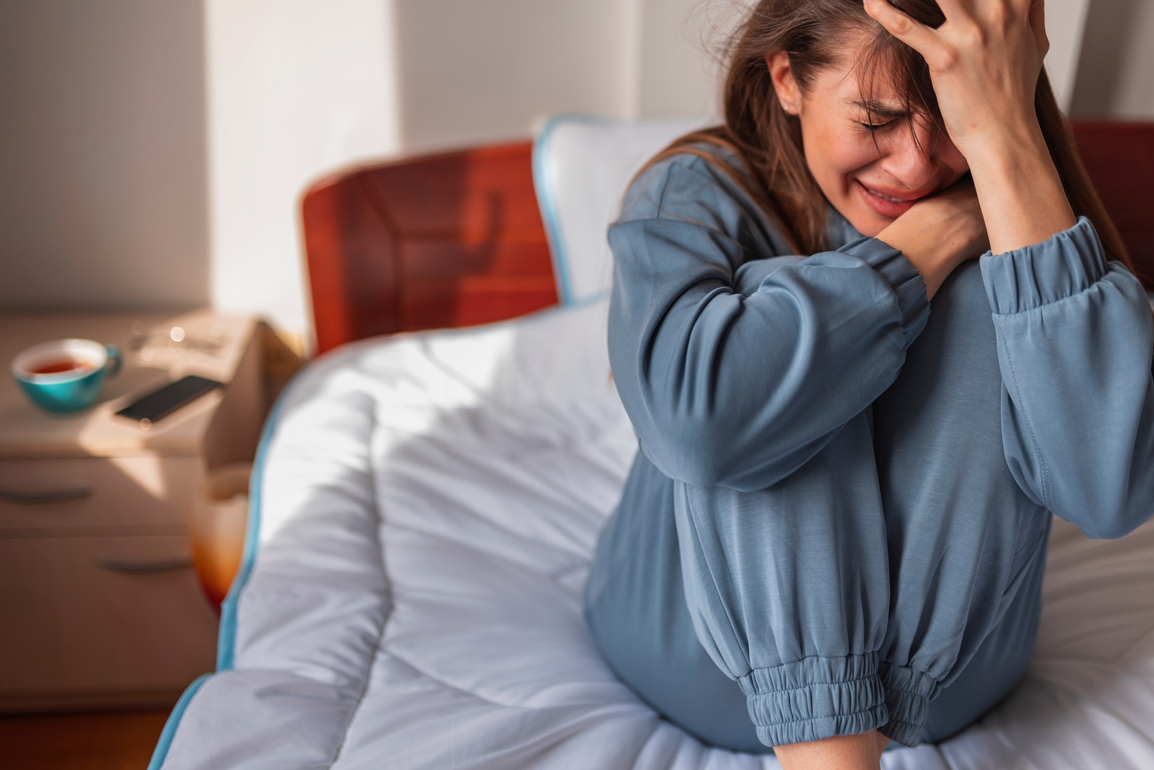 Anxious woman crying in bed